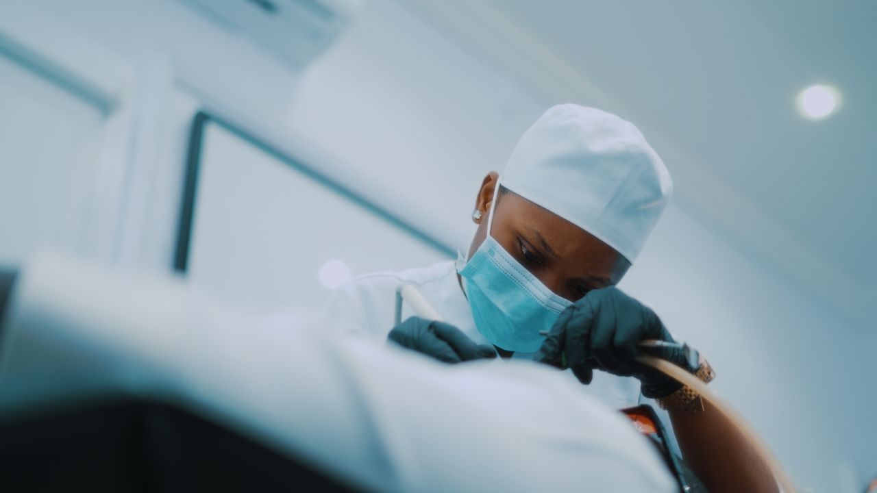 African American surgeon performing a detailed medical procedure in a modern hospital setting.